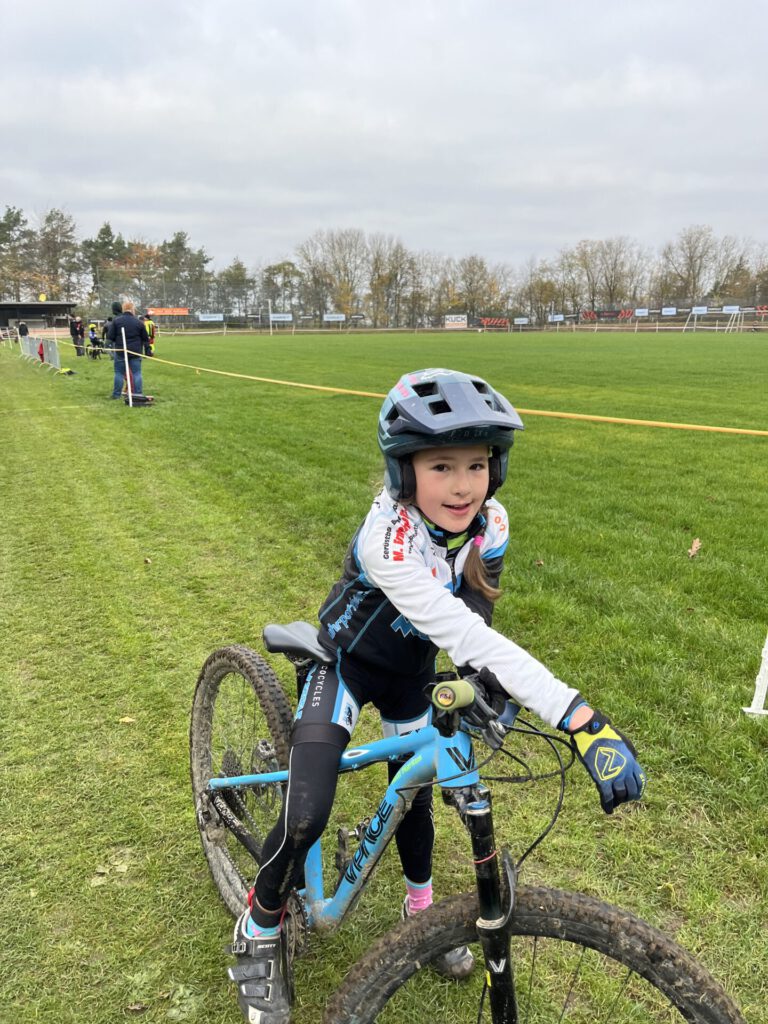 Eine junge Mountainbikerin sitzt auf ihrem Rad und schaut in die Kamera.