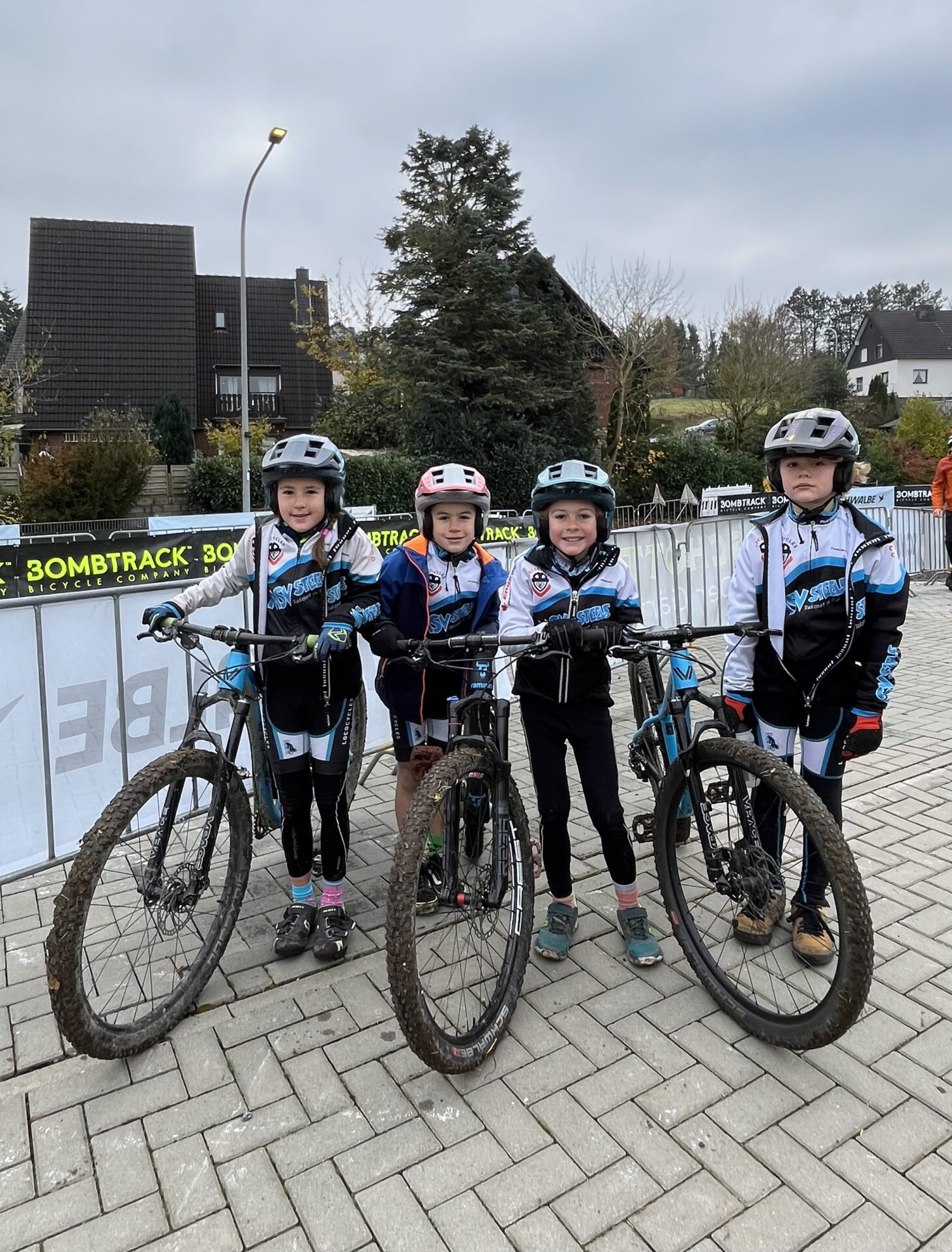 Vier junge Mountainbikerrinnen stehen neben ihren Rädern.