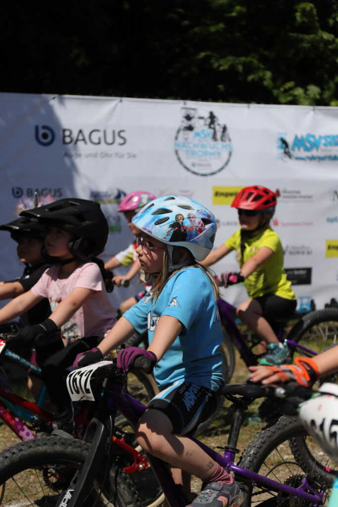 Kinder und Jugendliche fahren bei einem Mountainbikerennen.