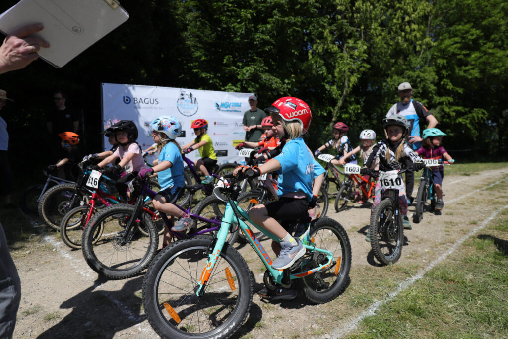 Kinder und Jugendliche fahren bei einem Mountainbikerennen.