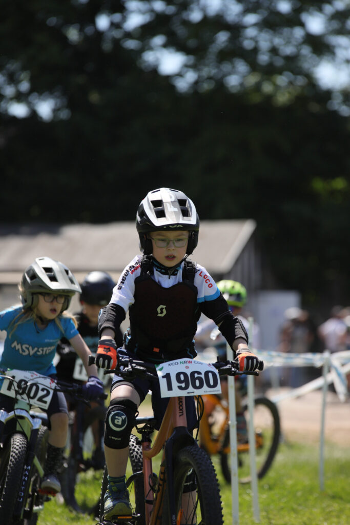 Kinder und Jugendliche fahren bei einem Mountainbikerennen.