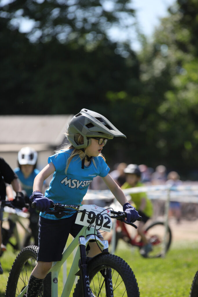 Kinder und Jugendliche fahren bei einem Mountainbikerennen.