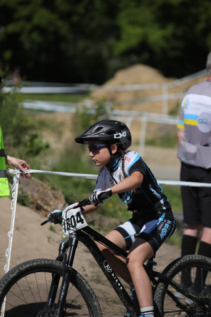 Kinder und Jugendliche fahren bei einem Mountainbikerennen.