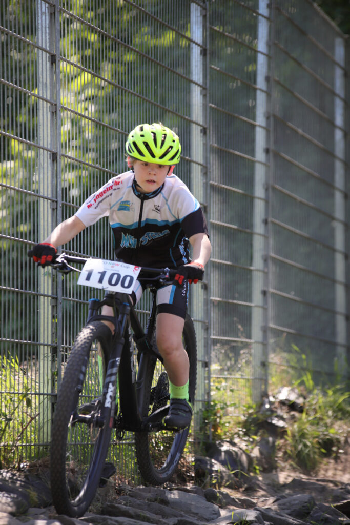 Kinder und Jugendliche fahren bei einem Mountainbikerennen.