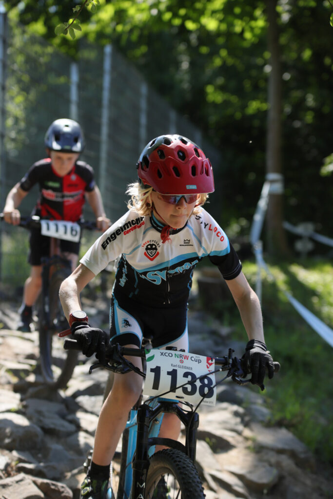 Kinder und Jugendliche fahren bei einem Mountainbikerennen.