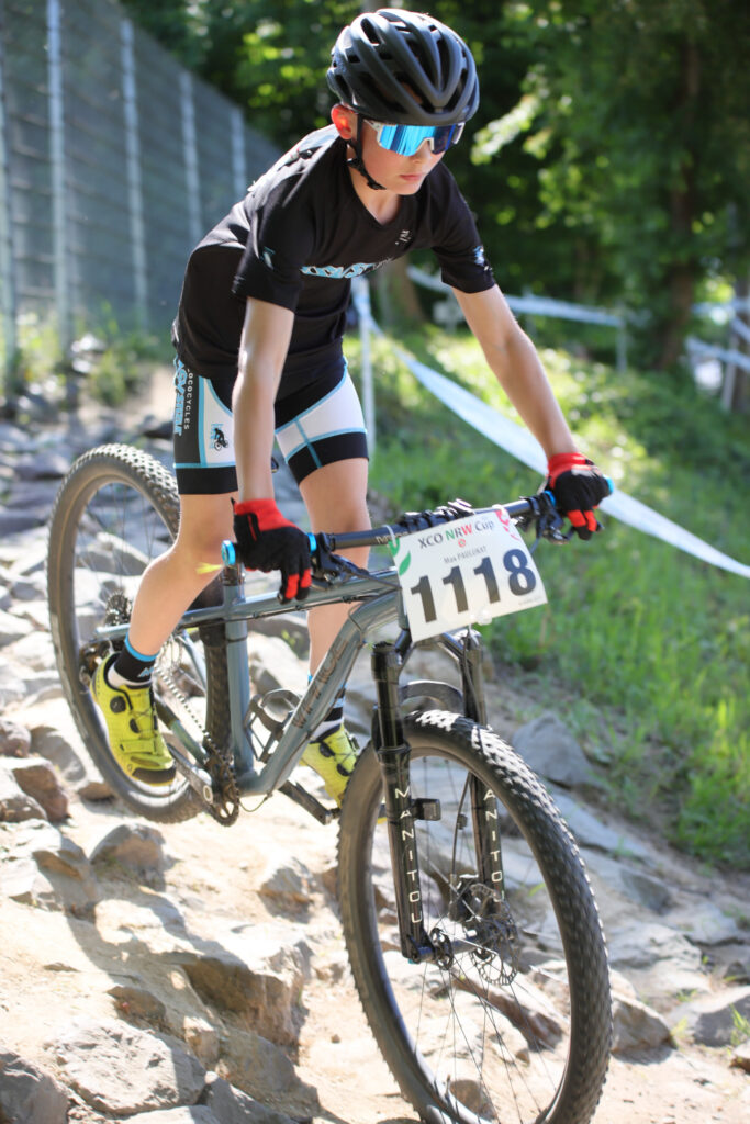 Kinder und Jugendliche fahren bei einem Mountainbikerennen.