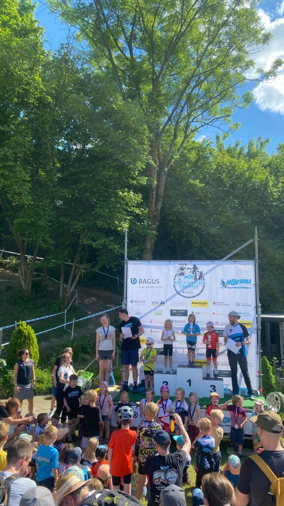 Jugendliche stehen auf einem Podium bei einer Siegerehrung.