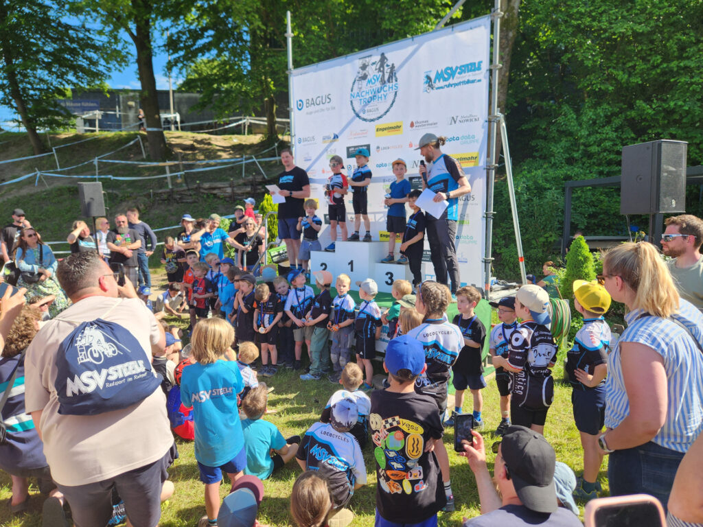 Jugendliche stehen auf einem Podium bei einer Siegerehrung.