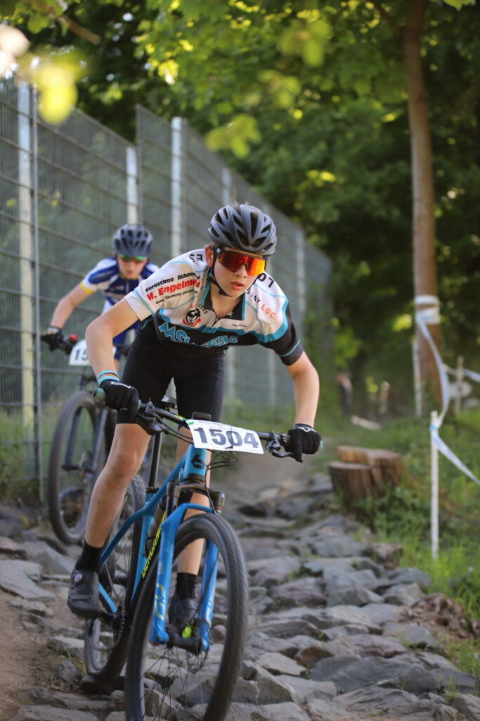 Kinder und Jugendliche fahren bei einem Mountainbikerennen.