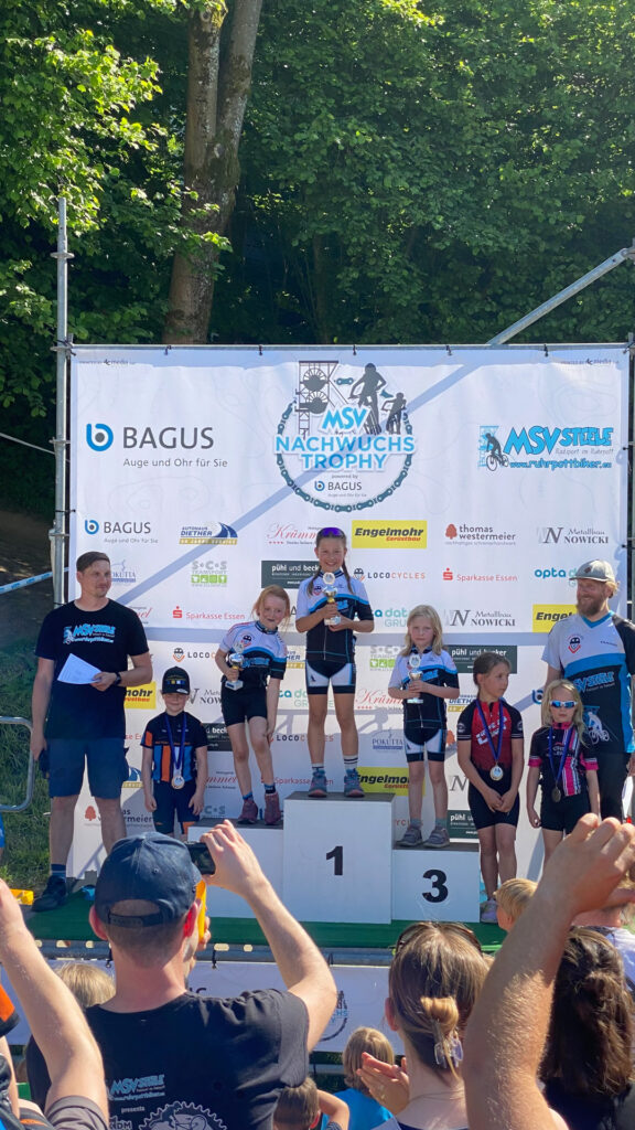 Jugendliche stehen auf einem Podium bei einer Siegerehrung.