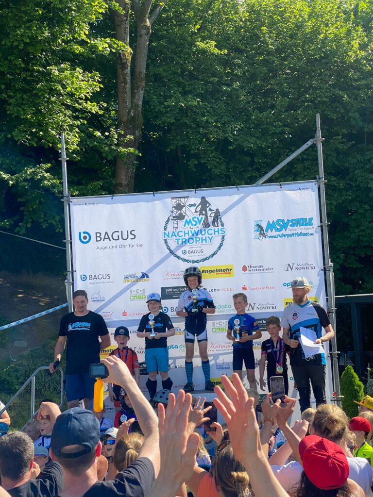 Jugendliche stehen auf einem Podium bei einer Siegerehrung.
