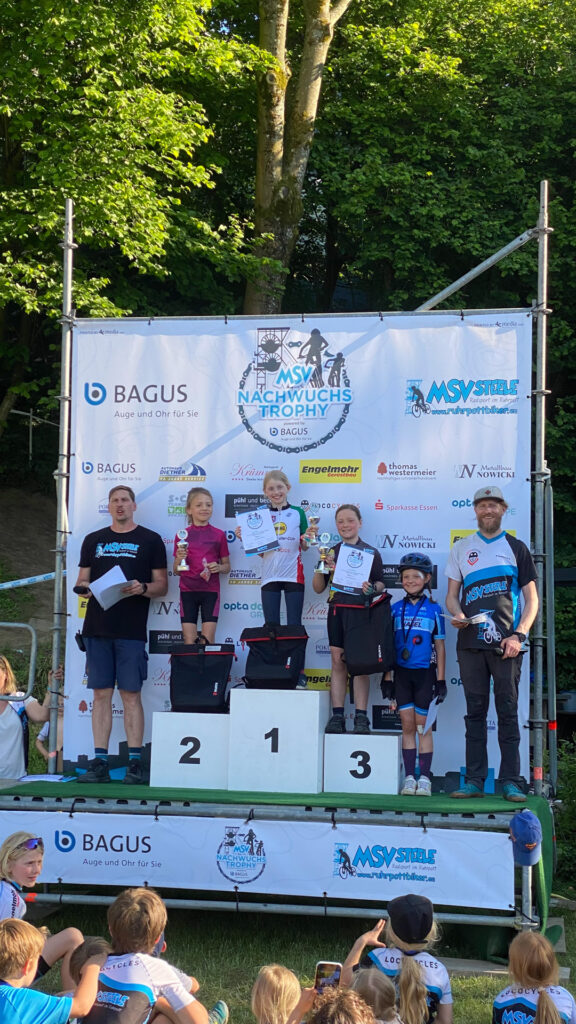 Jugendliche stehen auf einem Podium bei einer Siegerehrung.