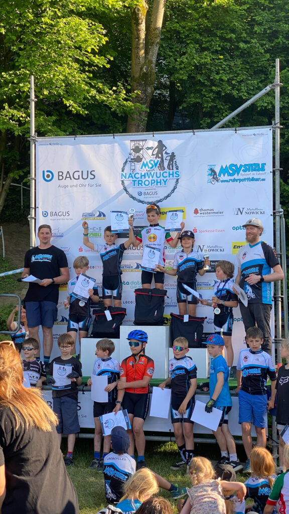 Jugendliche stehen auf einem Podium bei einer Siegerehrung.