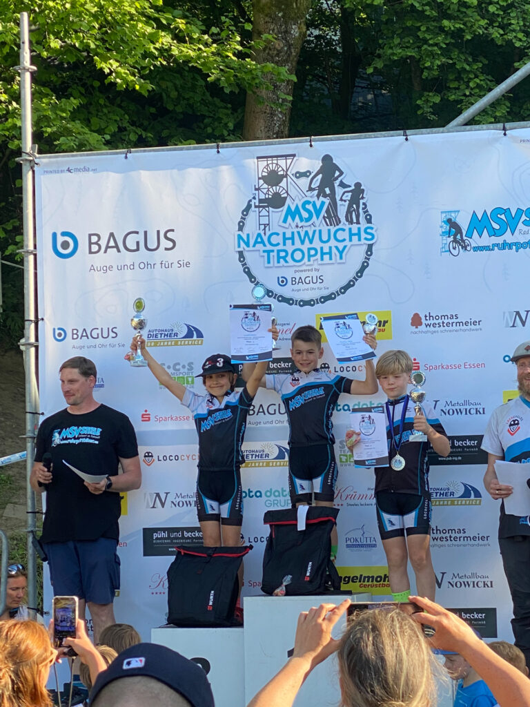 Jugendliche stehen auf einem Podium bei einer Siegerehrung.