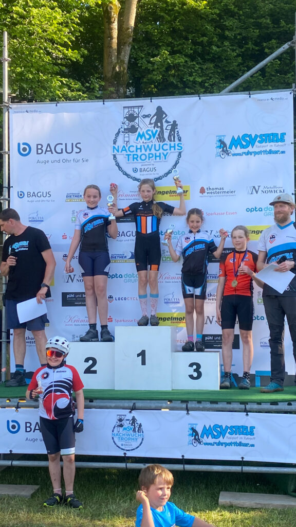 Jugendliche stehen auf einem Podium bei einer Siegerehrung.