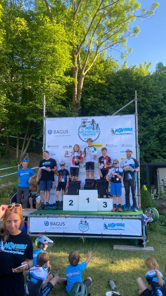 Jugendliche stehen auf einem Podium bei einer Siegerehrung.