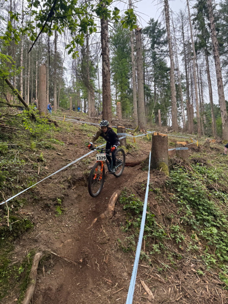 Jugendliche fahren ein Mountainbikerennen im Wald.