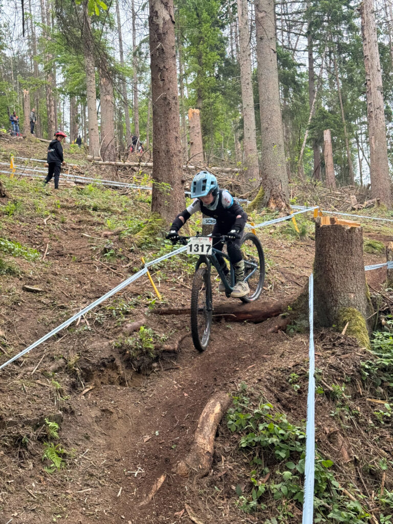 Jugendliche fahren ein Mountainbikerennen im Wald.