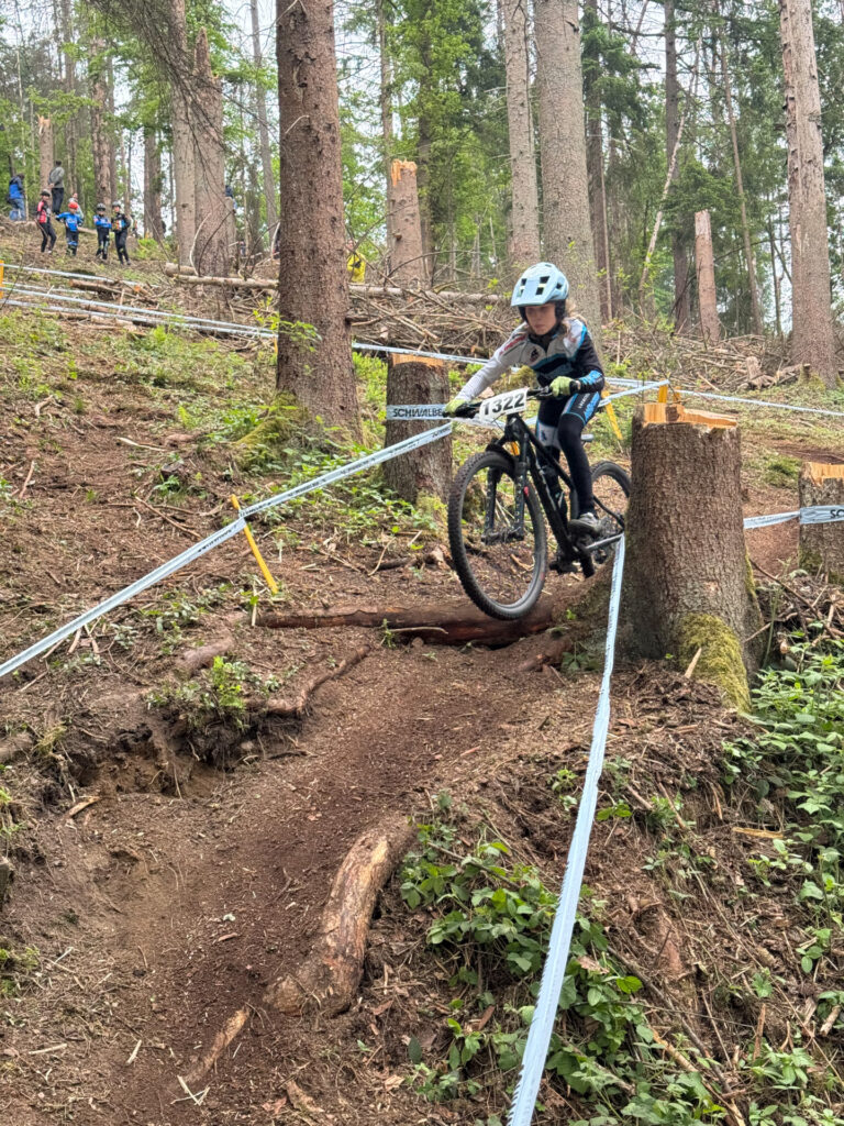 Jugendliche fahren ein Mountainbikerennen im Wald.