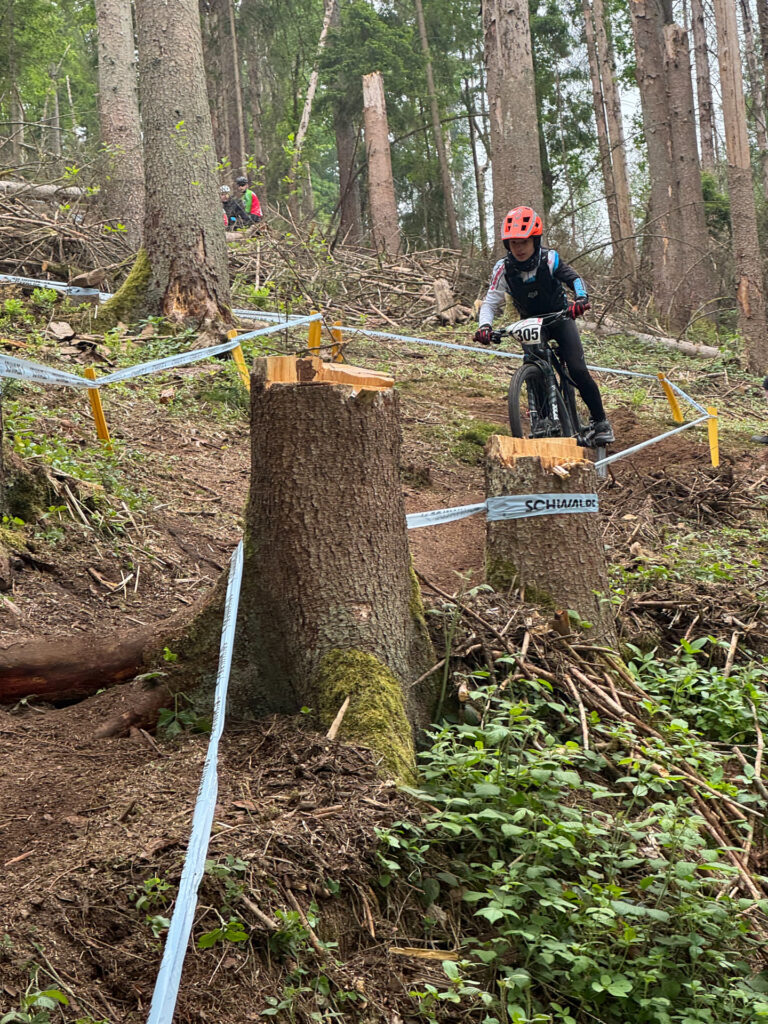 Jugendliche fahren ein Mountainbikerennen im Wald.