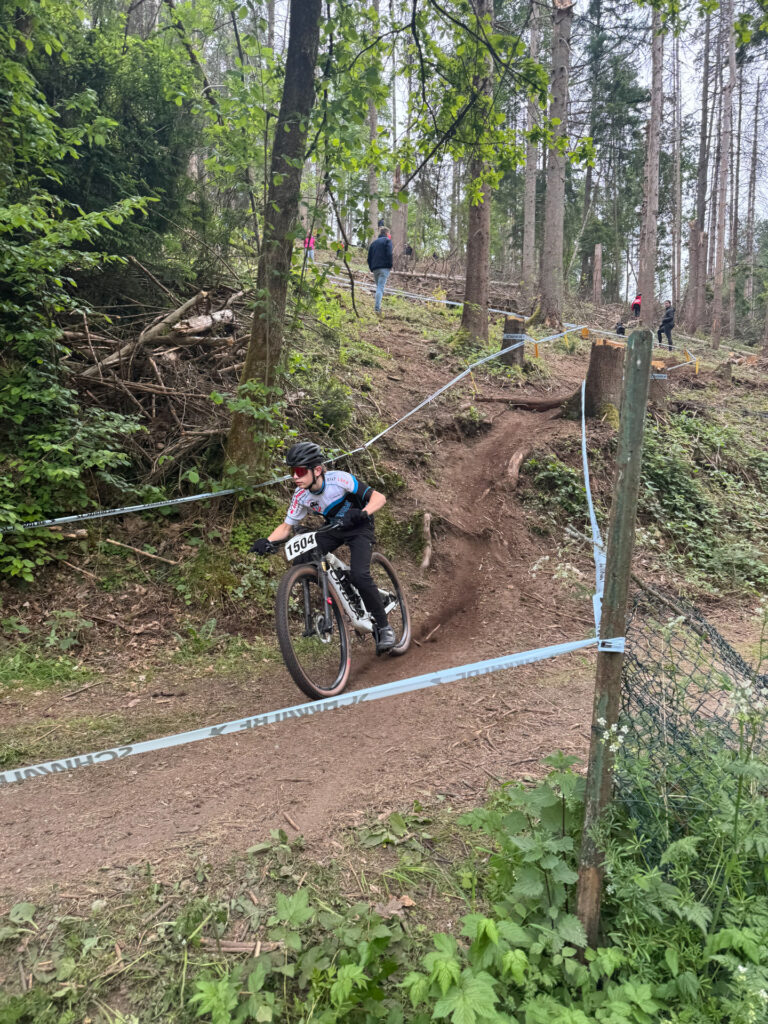 Jugendliche fahren ein Mountainbikerennen im Wald.