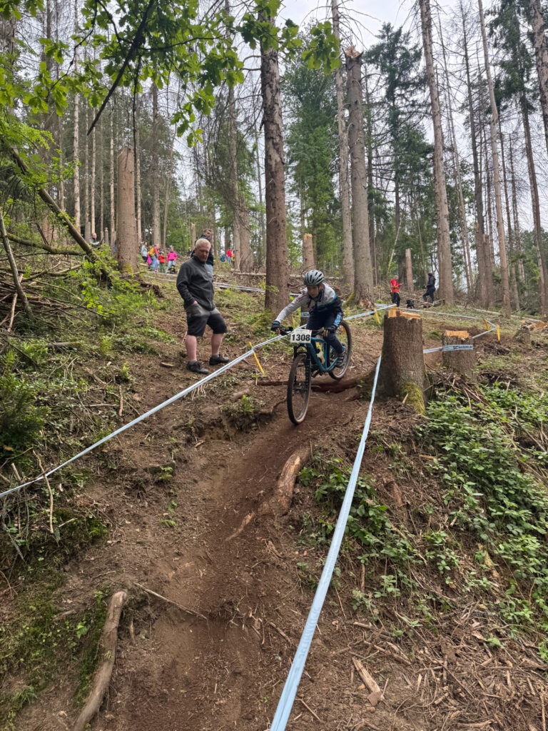 Jugendliche fahren ein Mountainbikerennen im Wald.