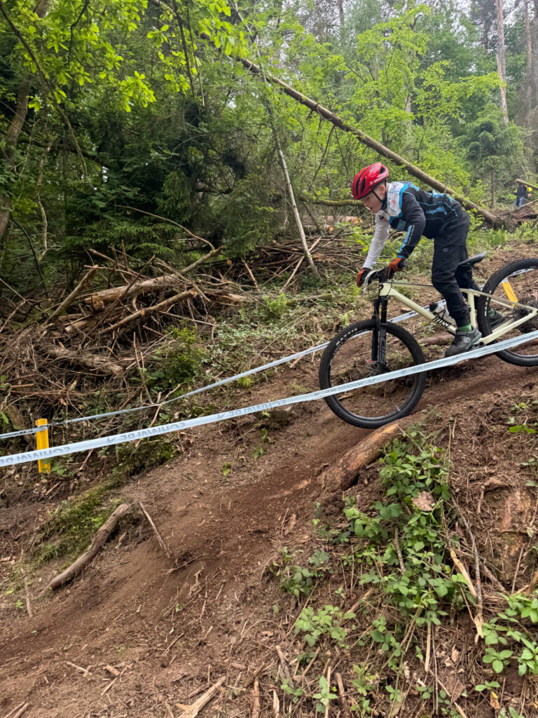 Jugendliche fahren ein Mountainbikerennen im Wald.