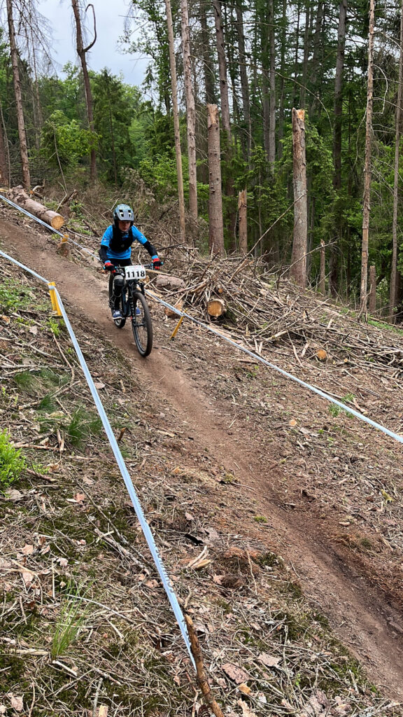 Jugendliche fahren ein Mountainbikerennen im Wald.