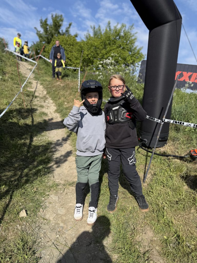 Jugendliche Mountainbikefahrer posieren auf einer Rennstrecke.