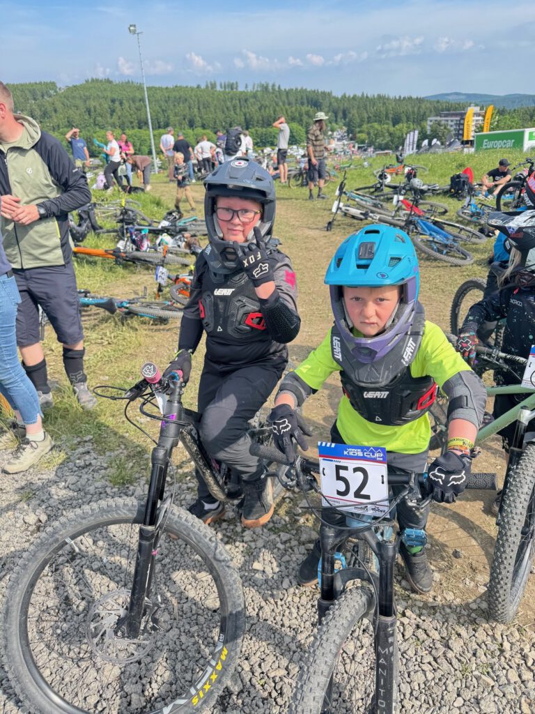 Kinder sitzen auf Downhillbikes.
