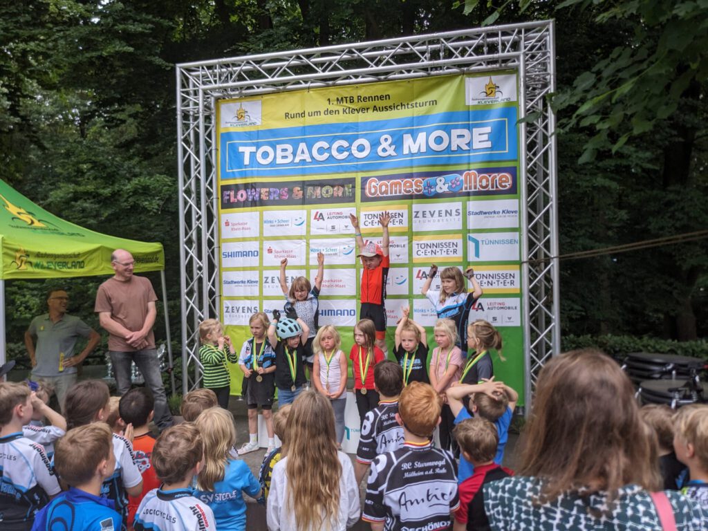 Kinder stehen bei einer Siegerehrung auf einem Podest.