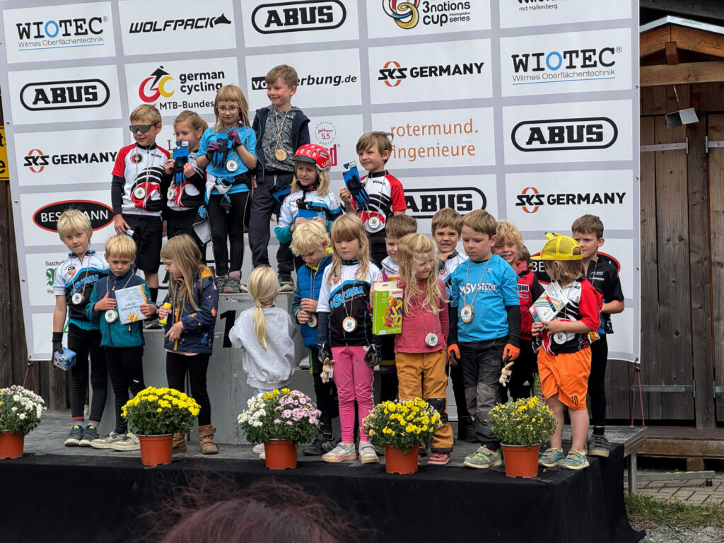 Kinder stehen bei einem MTB-Rennen auf dem Treppchen.