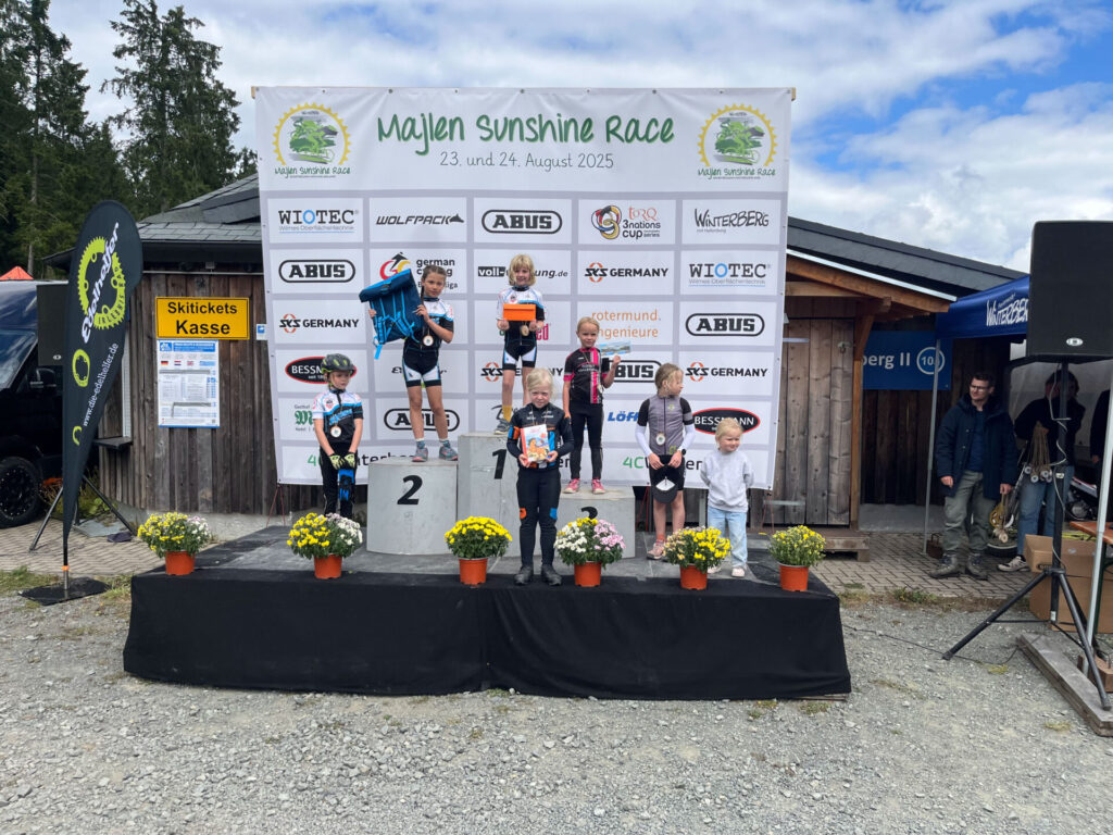 Kinder stehen bei einem MTB-Rennen auf dem Treppchen.