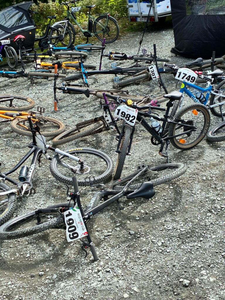 Mountainbikes mit Startnummern liegen auf einem Kiesweg.