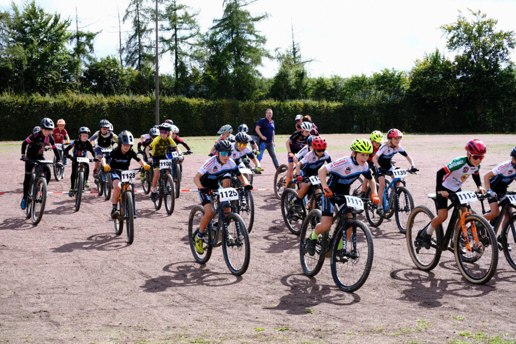 Kinder und Jugendliche nehmen an einem Mountainbikerennen teil.