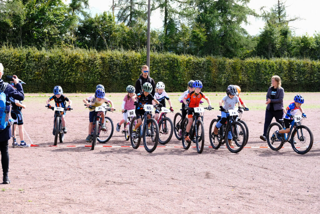 Kinder und Jugendliche nehmen an einem Mountainbikerennen teil.