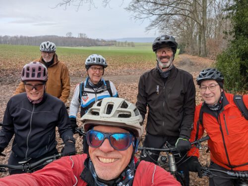 Sechs Radfahrer des MSV Essen-Steele 2011 e.V. posieren lächelnd im Wald für ein Foto.