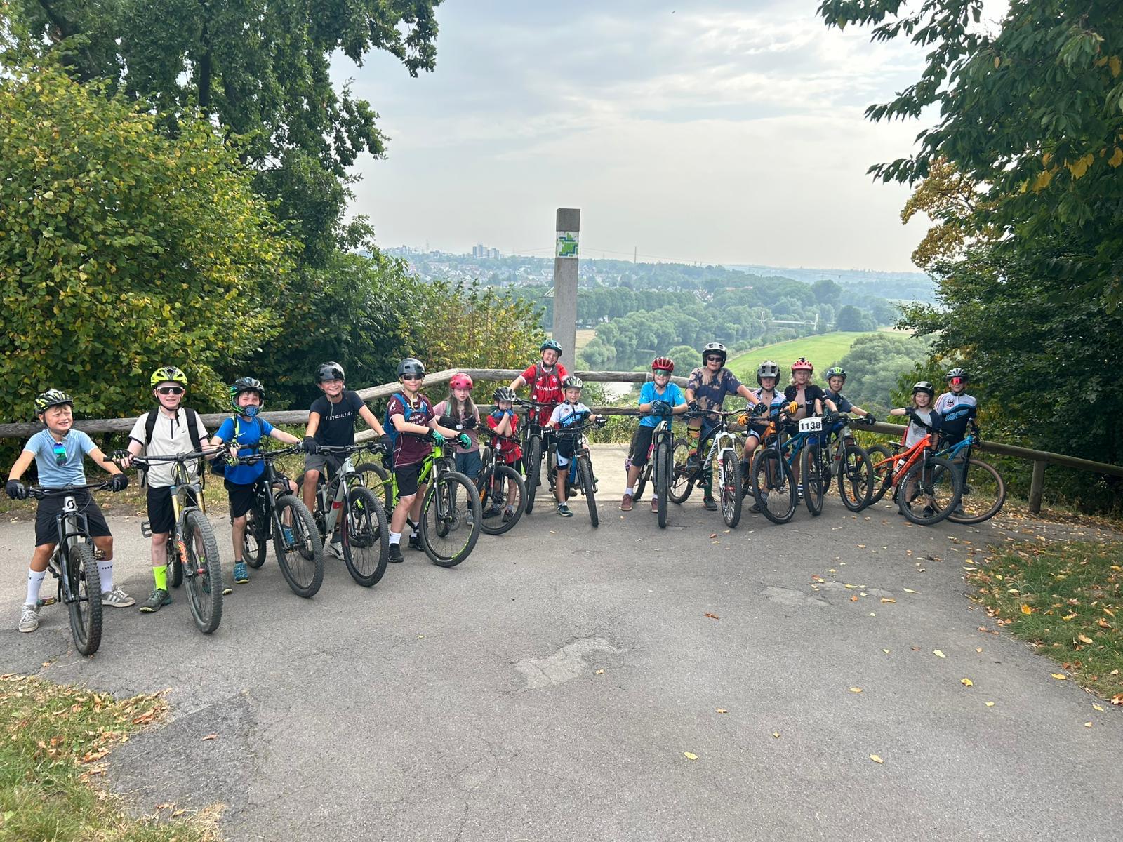 Kinder mit Mountainbikes stehen auf einer Brücke