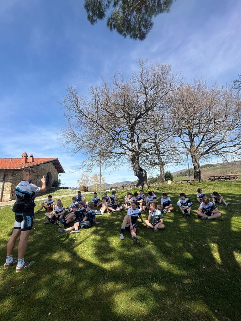 Trainer erklärt Mountainbike-Techniken während des Trainingslagers in der Toskana, um die Fähigkeiten der Sportler zu verbessern.