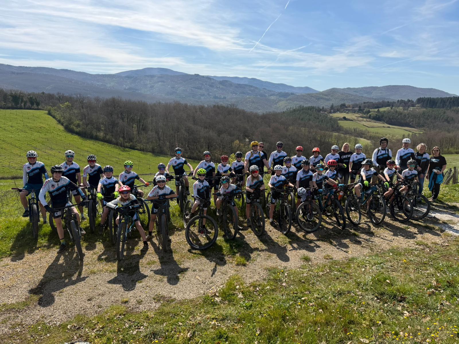 Gruppenfoto der Teilnehmer des Trainingslagers in der Toskana, umgeben von malerischer Landschaft und strahlendem Sonnenschein.