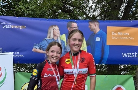 Zwei junge Mountainbikerinnen lächeln stolz mit Medaillen bei der Landesmeisterschaft Rees. | © Name